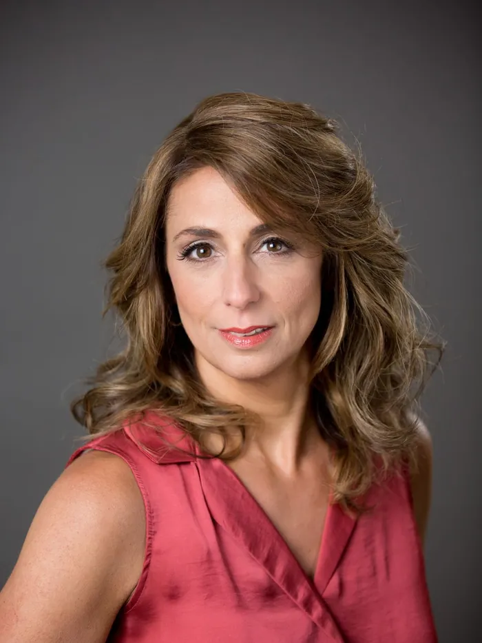 A finished womens hair system seen up close: a soft natural hairline, individual strands visible at the front, shoulder-length layers