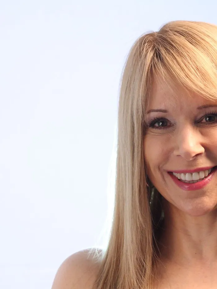 Finished long blonde hair with a soft fringe and a natural front hairline, studio portrait