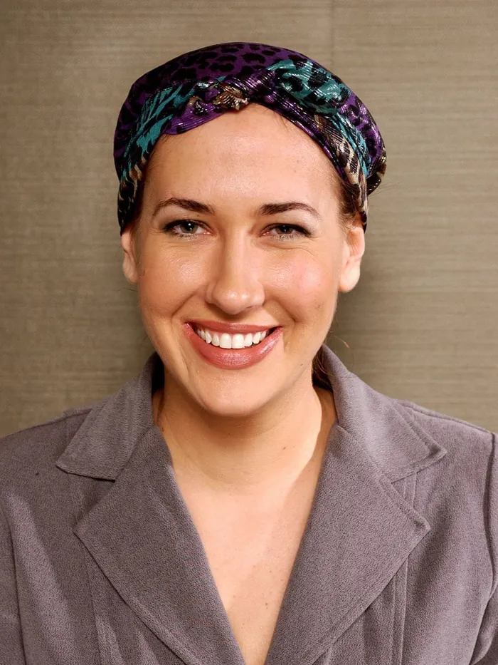 Before: total hair loss covered by a patterned head scarf, gray blazer, textured backdrop