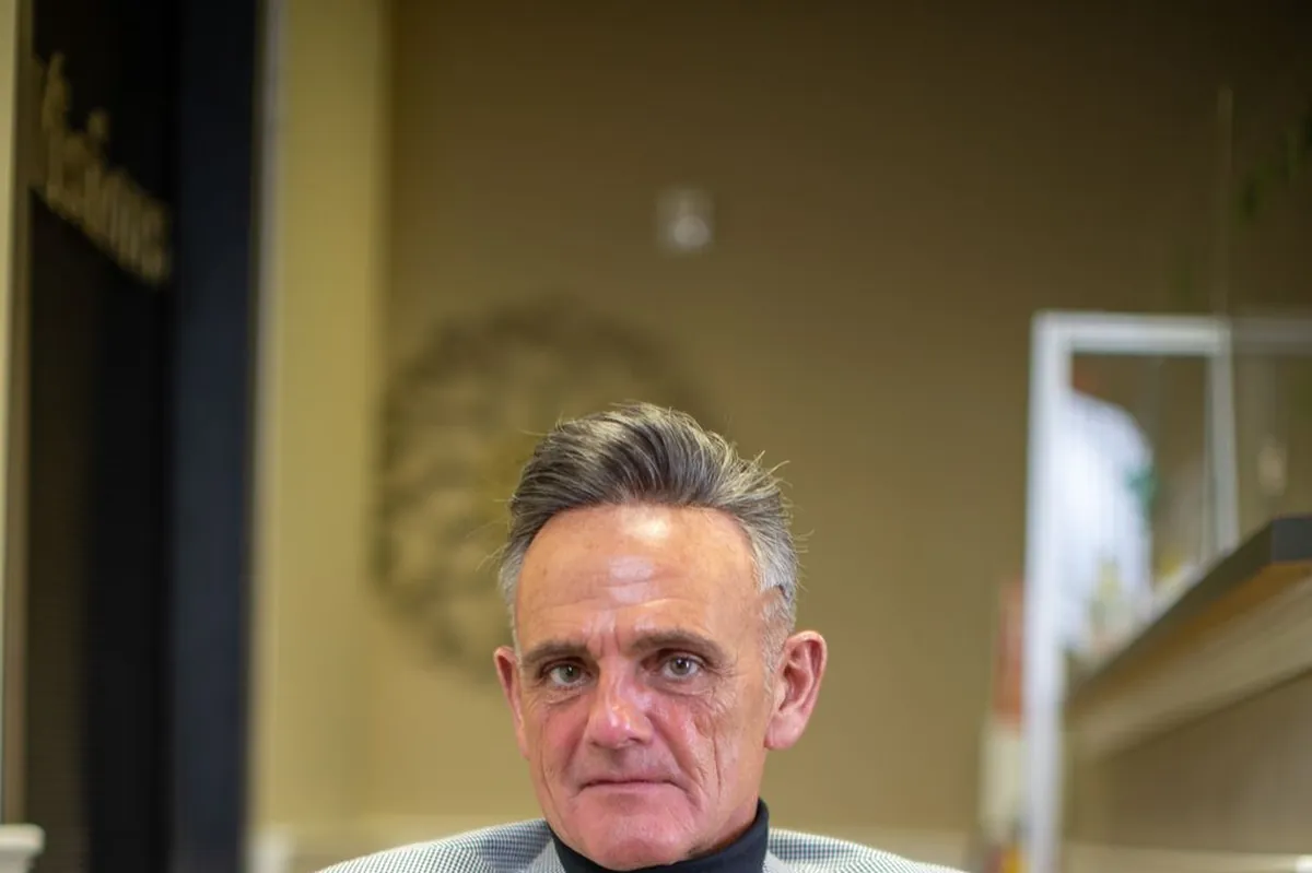 Client seated calmly with hands folded in a light blazer during a pricing conversation