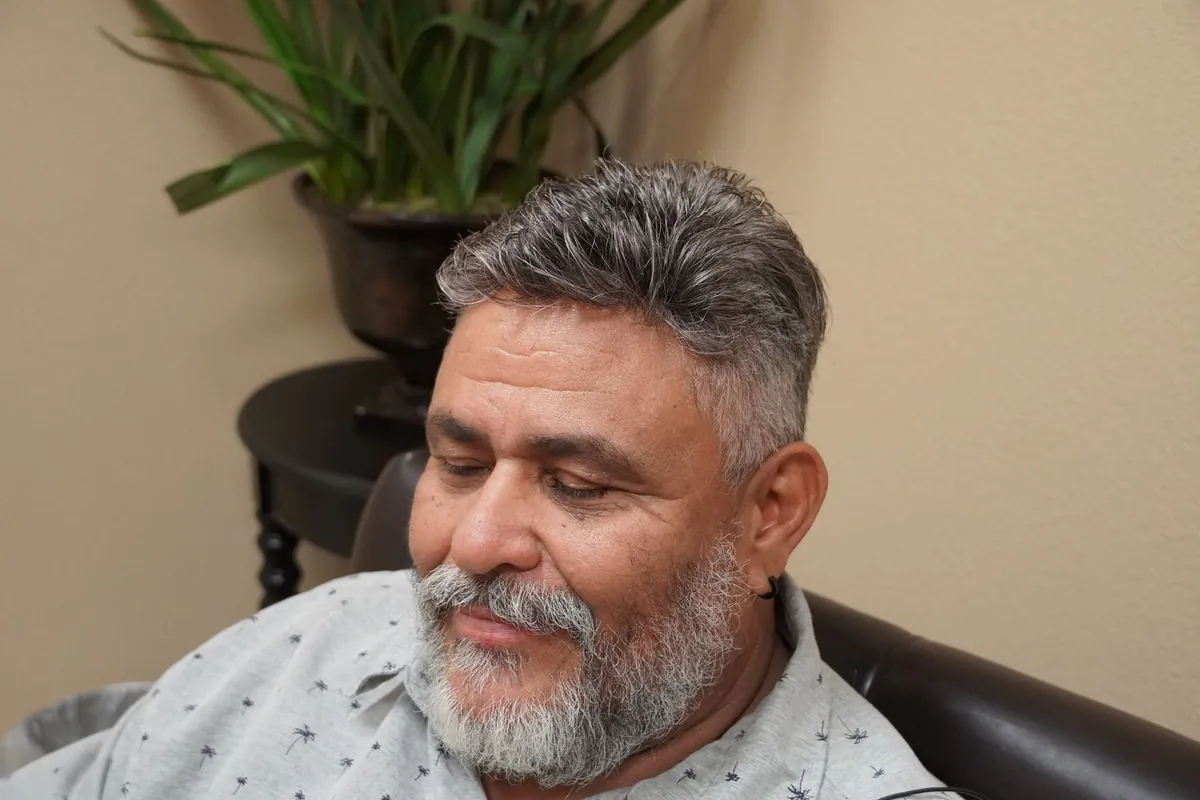 Client relaxed in the styling chair with an easy half smile during his appointment