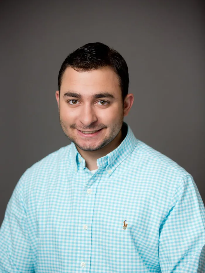 After: a full dark front hairline, same check shirt and same backdrop