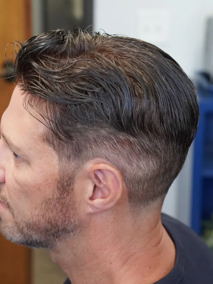 Textured swept-back mens hair replacement system with faded sides, left profile