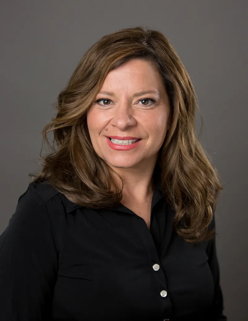 Karen smiling after her women's hair replacement, studio portrait
